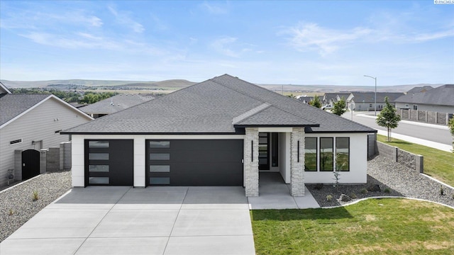 561 Lazio Way, Richland, WA 99352 - contemporary house with a garage, concrete driveway, roof with shingles, and a mountain view