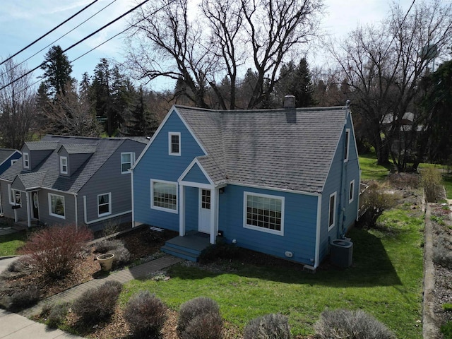 525 SE Water St, Pullman, WA 99163 - view of front of house featuring a chimney, a shingled roof, a front yard, and central AC