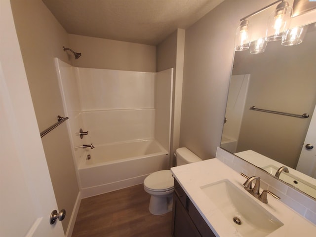 bathroom featuring wood finished floors, toilet, shower / bathtub combination, and vanity