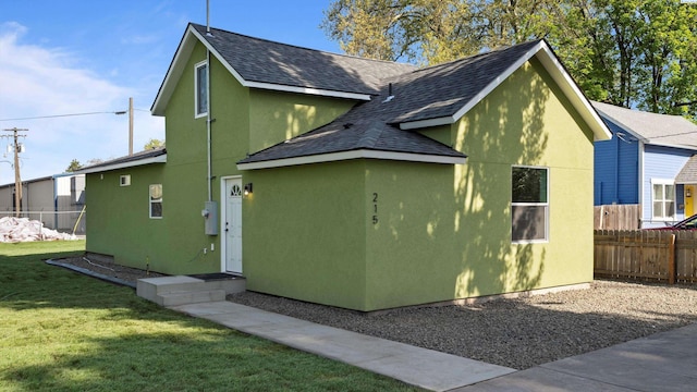 215 E Oak St, Walla Walla, WA 99362 - view of property exterior with a lawn, a shingled roof, stucco siding, and fence