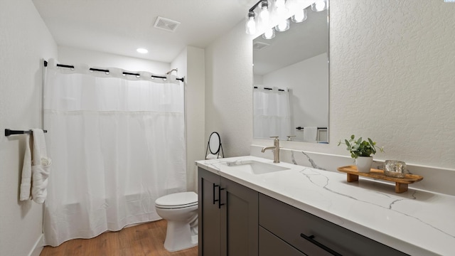 215 E Oak St, Walla Walla, WA 99362 - bathroom with wood finished floors, toilet, a textured wall, vanity, and visible vents