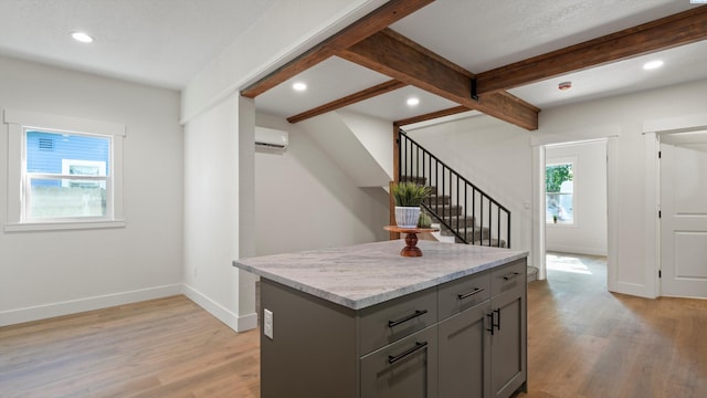 215 E Oak St, Walla Walla, WA 99362 - kitchen featuring baseboards, light wood-style floors, a wall mounted air conditioner, gray cabinetry, and beam ceiling