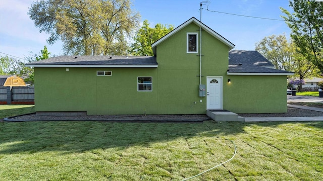 215 E Oak St, Walla Walla, WA 99362 - back of property featuring stucco siding, fence, roof with shingles, and a yard