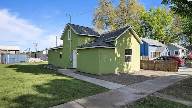 215 E Oak St, Walla Walla, WA 99362 - view of side of property with a yard, a shingled roof, stucco siding, and fence