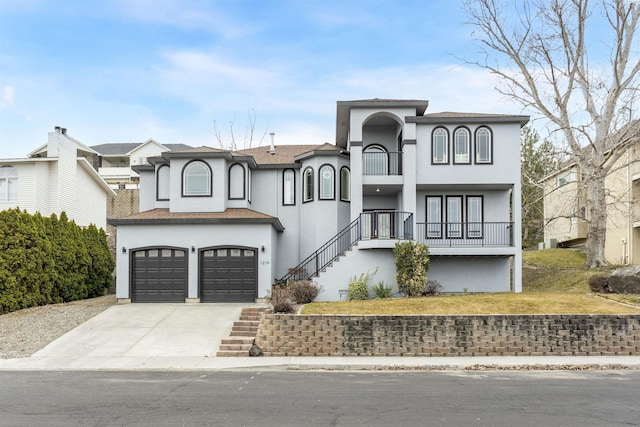mediterranean / spanish-style home with an attached garage, stucco siding, and driveway