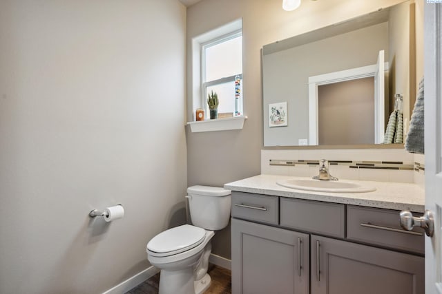 2855 S Dawes Pl, Kennewick, WA 99338 - half bathroom featuring vanity, toilet, baseboards, wood finished floors, and tasteful backsplash