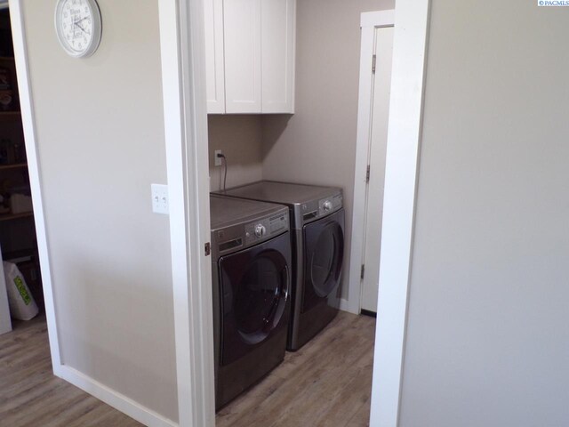 166214 W Johnson Rd, Prosser, WA 99350 - washroom featuring independent washer and dryer, light wood finished floors, and cabinet space