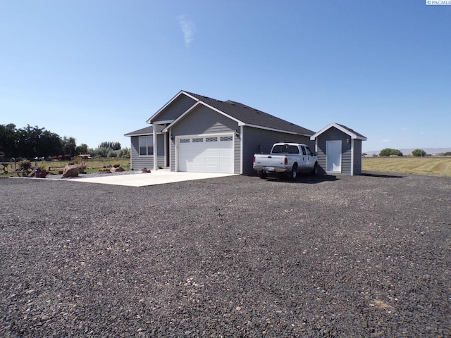 166214 W Johnson Rd, Prosser, WA 99350 - view of front facade featuring an attached garage, a shed, and driveway