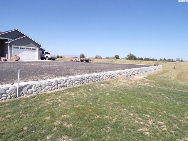 166214 W Johnson Rd, Prosser, WA 99350 - view of grassy yard with a garage, a rural view, and driveway