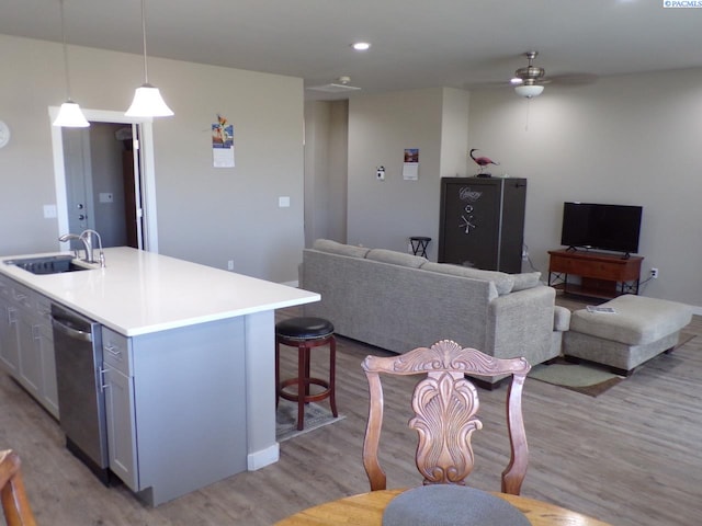 166214 W Johnson Rd, Prosser, WA 99350 - kitchen with stainless steel dishwasher, light wood-style flooring, a ceiling fan, an island with sink, and light countertops