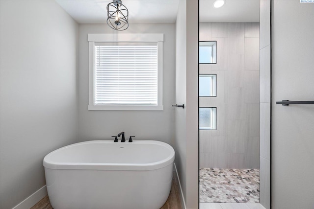 bathroom featuring a healthy amount of sunlight and shower with separate bathtub