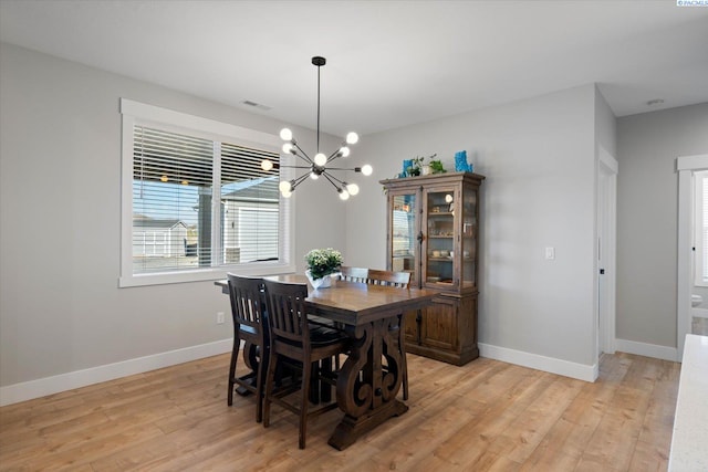 dining room featuring an inviting chandelier and light wood-type flooring