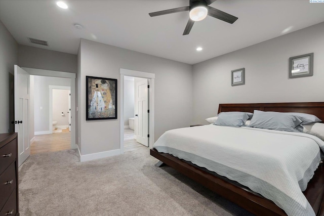 carpeted bedroom with ceiling fan and ensuite bath