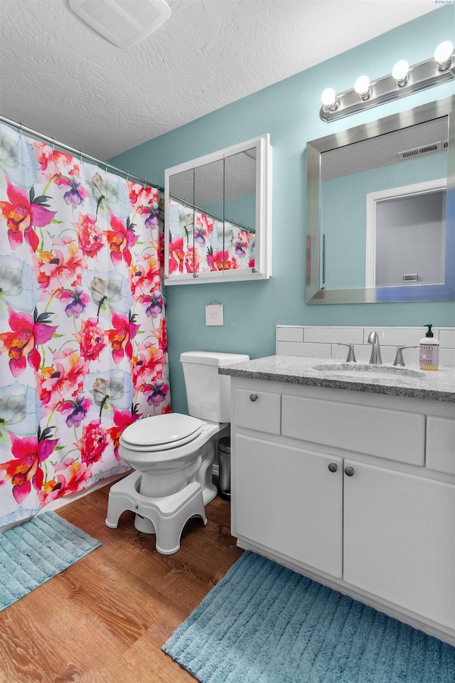4500 S Dayton Ct, Kennewick, WA 99337 - full bath with wood finished floors, toilet, vanity, a textured ceiling, and a shower with curtain