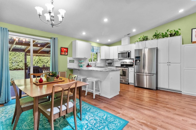 4500 S Dayton Ct, Kennewick, WA 99337 - dining room with plenty of natural light, a chandelier, lofted ceiling, light wood-type flooring, and recessed lighting