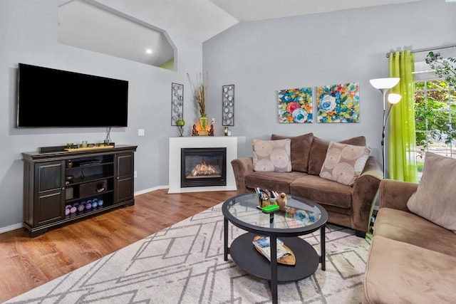 4500 S Dayton Ct, Kennewick, WA 99337 - living area with wood finished floors, lofted ceiling, a glass covered fireplace, and baseboards