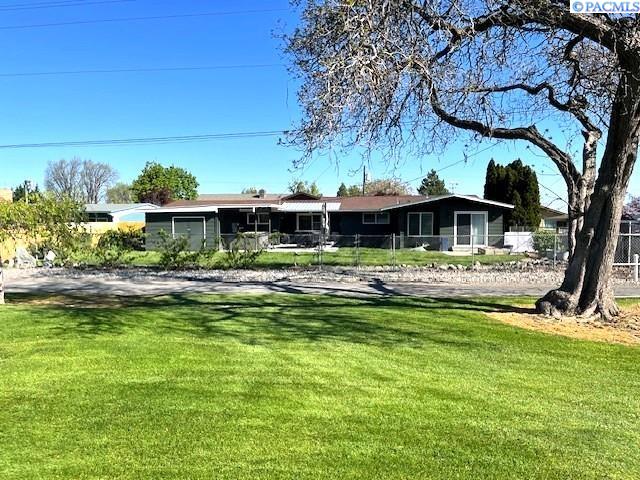 rear view of house featuring fence and a yard