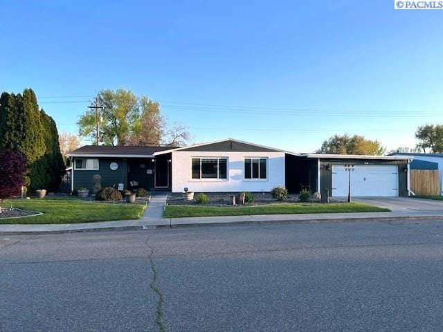 view of front of property with an attached garage, driveway, and a front lawn