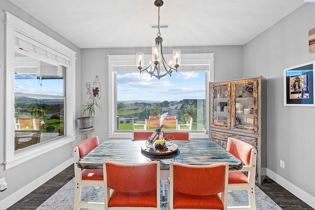 dining area with a chandelier, wood finished floors, and baseboards