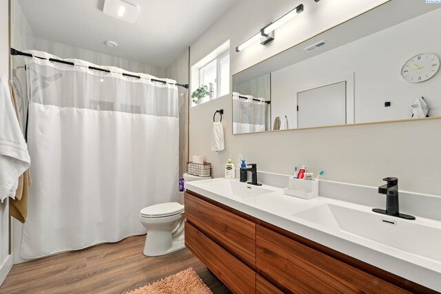 1006 Adams St, Richland, WA 99352 - bathroom featuring double vanity, wood finished floors, toilet, and a shower with shower curtain