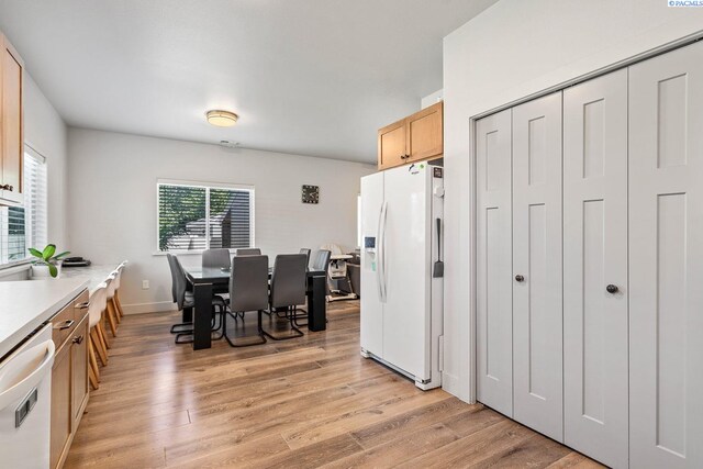 1006 Adams St, Richland, WA 99352 - kitchen with white appliances, light wood-style flooring, light countertops, light brown cabinetry, and baseboards