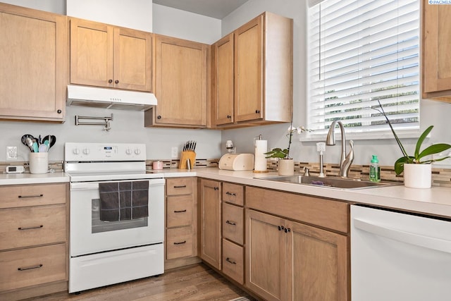 1006 Adams St, Richland, WA 99352 - kitchen with white appliances, under cabinet range hood, a sink, light countertops, and light wood-style flooring
