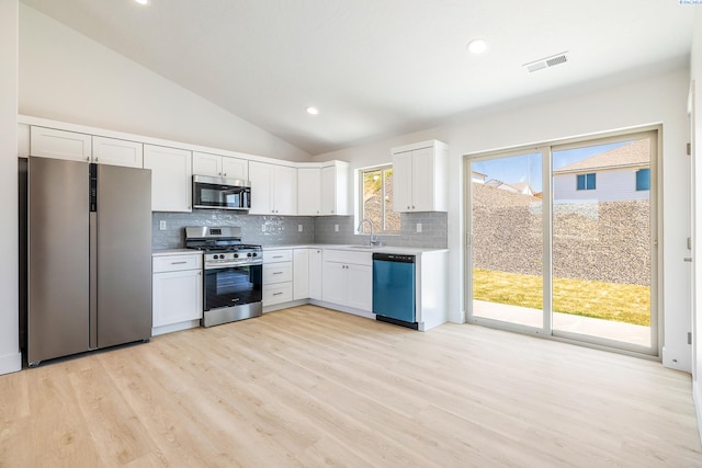 2967 S Penn St, Kennewick, WA 99338 - kitchen with appliances with stainless steel finishes, light countertops, decorative backsplash, lofted ceiling, and light wood-style flooring