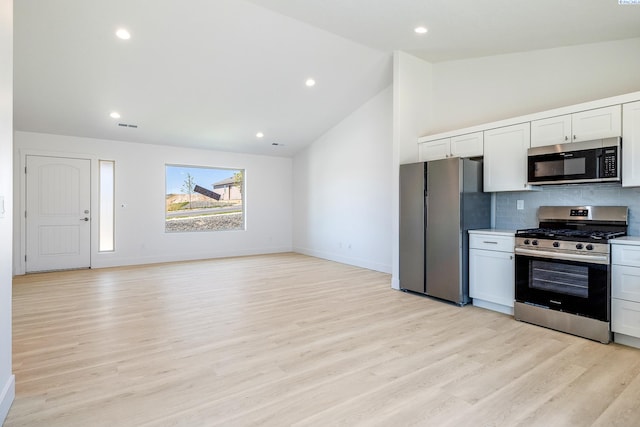 2967 S Penn St, Kennewick, WA 99338 - kitchen with appliances with stainless steel finishes, tasteful backsplash, light wood finished floors, vaulted ceiling, and white cabinets