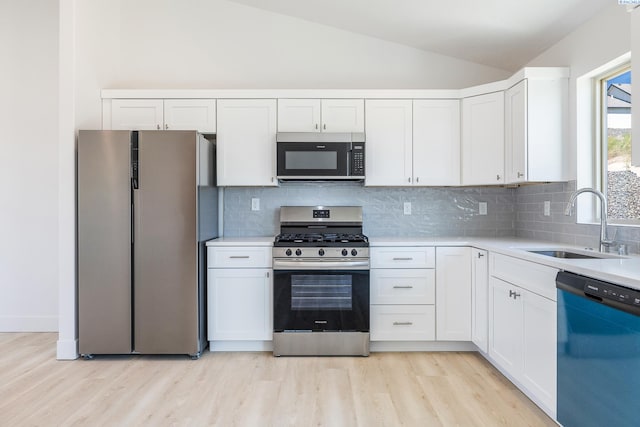 2967 S Penn St, Kennewick, WA 99338 - kitchen featuring appliances with stainless steel finishes, a sink, lofted ceiling, light wood-style floors, and white cabinetry