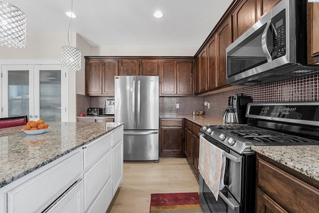 6013 Somerset Ln, Pasco, WA 99301 - kitchen featuring appliances with stainless steel finishes, light wood-style flooring, tasteful backsplash, light stone countertops, and recessed lighting
