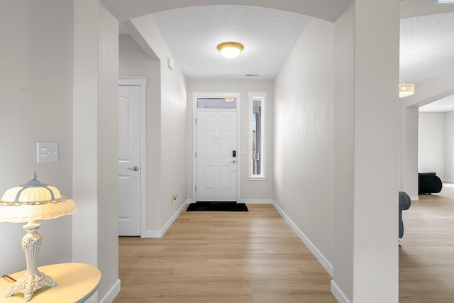 6013 Somerset Ln, Pasco, WA 99301 - foyer featuring arched walkways, light wood finished floors, and baseboards