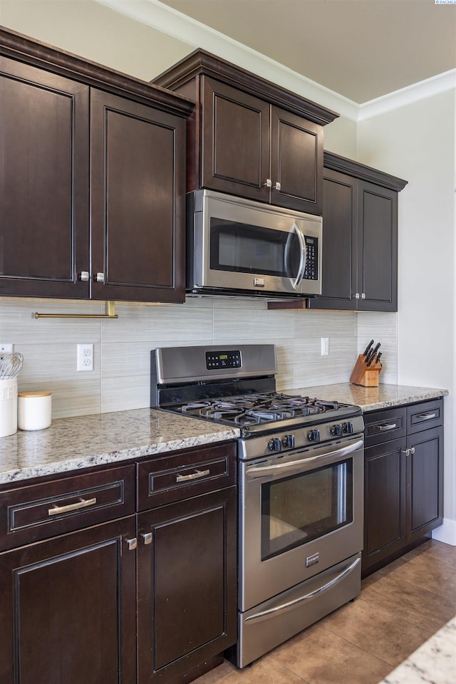 3512 El Paso Dr, Pasco, WA 99301 - kitchen featuring appliances with stainless steel finishes, light stone countertops, dark brown cabinets, decorative backsplash, and crown molding