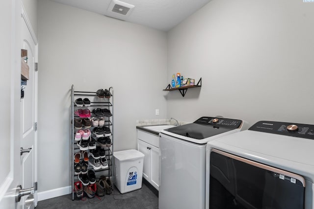 laundry room with visible vents, baseboards, cabinet space, independent washer and dryer, and a sink