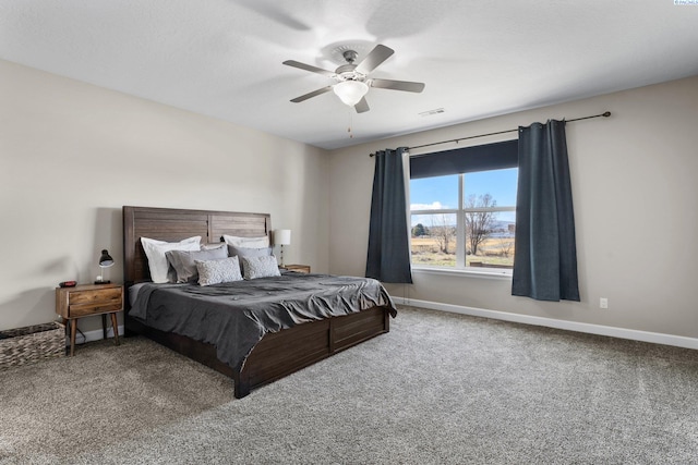 carpeted bedroom with a ceiling fan, baseboards, and visible vents