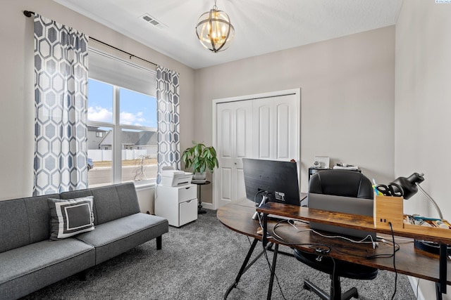 carpeted home office with baseboards, visible vents, and a chandelier