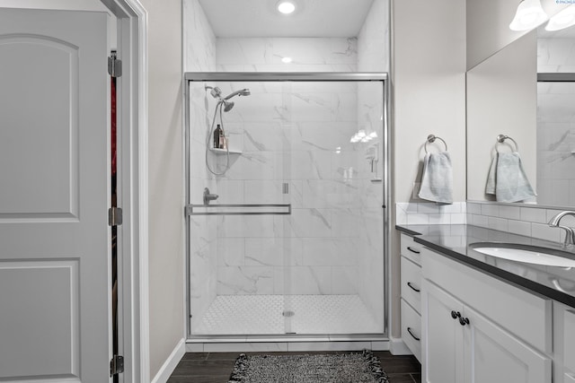 bathroom featuring vanity, wood finished floors, and a shower stall