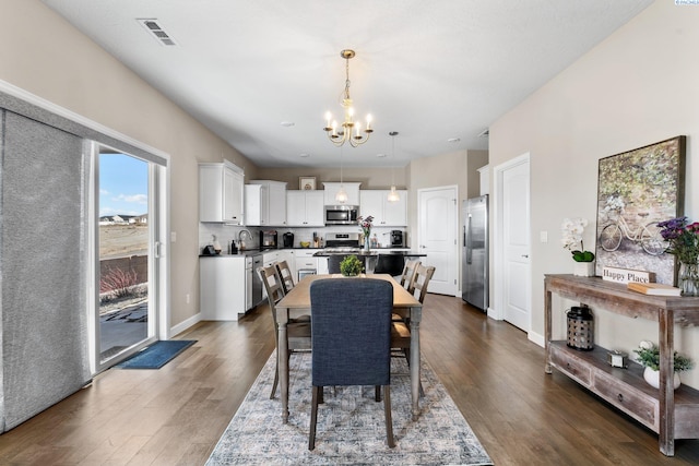 dining room featuring visible vents, baseboards, an inviting chandelier, and dark wood finished floors