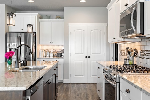 6416 Recurve Rd, Pasco, WA 99301 - kitchen with appliances with stainless steel finishes, a sink, dark wood finished floors, backsplash, and white cabinets