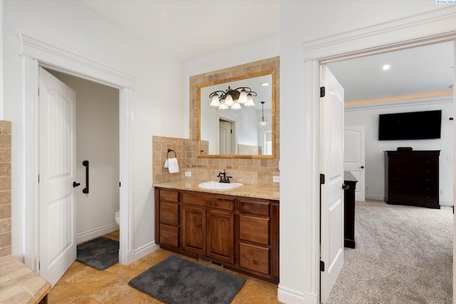 1010 Christopher Ln, Pasco, WA 99301 - bathroom featuring vanity, toilet, decorative backsplash, and baseboards