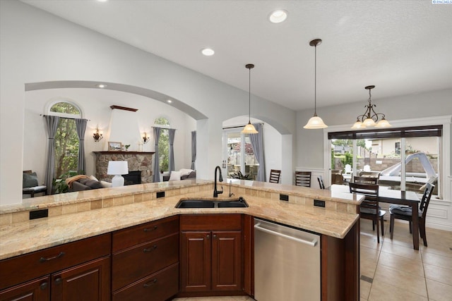 1010 Christopher Ln, Pasco, WA 99301 - kitchen with dishwasher, a sink, arched walkways, a stone fireplace, and light stone counters
