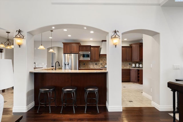 1010 Christopher Ln, Pasco, WA 99301 - kitchen with stainless steel appliances, a kitchen bar, light wood-style flooring, tasteful backsplash, and recessed lighting