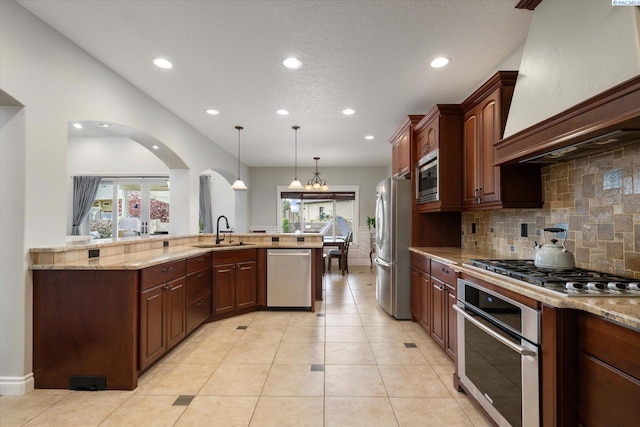 1010 Christopher Ln, Pasco, WA 99301 - kitchen featuring stainless steel appliances, premium range hood, a sink, recessed lighting, and arched walkways