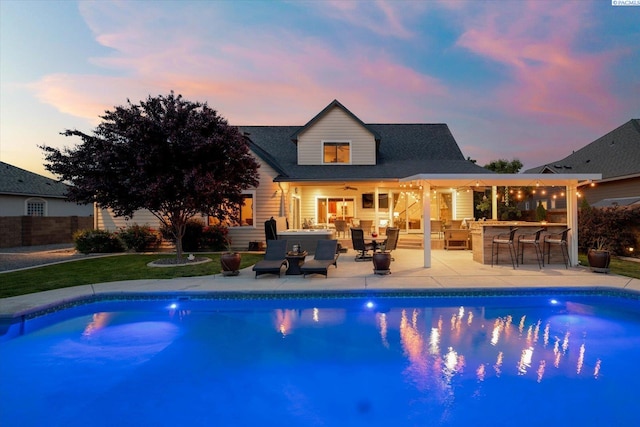 1010 Christopher Ln, Pasco, WA 99301 - back of house at dusk featuring a ceiling fan, an outdoor pool, and a patio