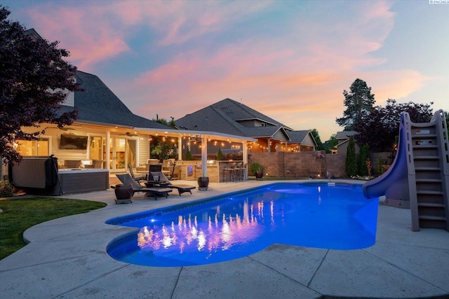 1010 Christopher Ln, Pasco, WA 99301 - pool at dusk with a water slide, a patio, and a fenced backyard