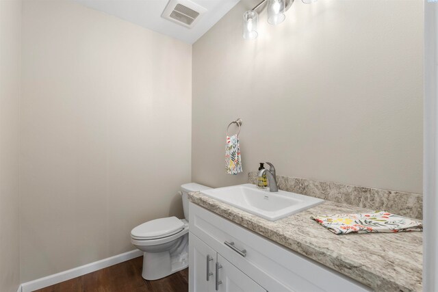 bathroom with hardwood / wood-style flooring, vanity, and toilet