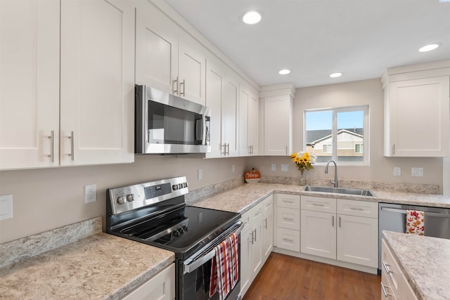 kitchen featuring white cabinetry, sink, dark hardwood / wood-style flooring, light stone counters, and stainless steel appliances