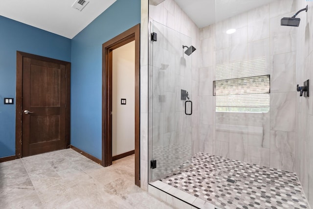 full bathroom with a shower stall and baseboards