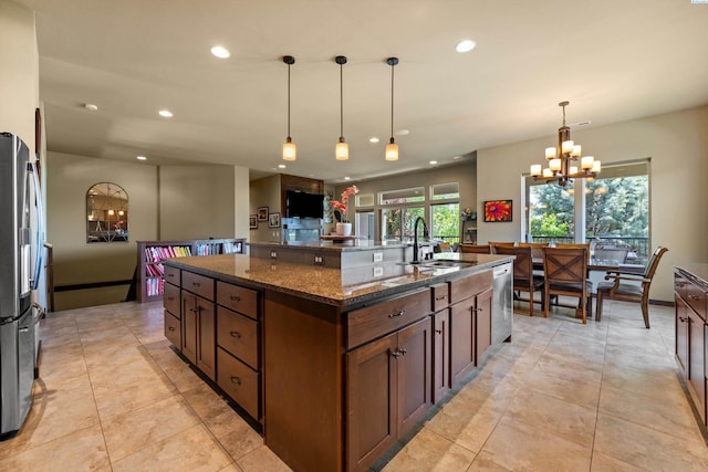 kitchen with a chandelier, a sink, recessed lighting, dark stone counters, and appliances with stainless steel finishes