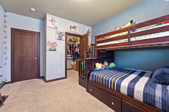 carpeted bedroom with baseboards, a walk in closet, and a closet