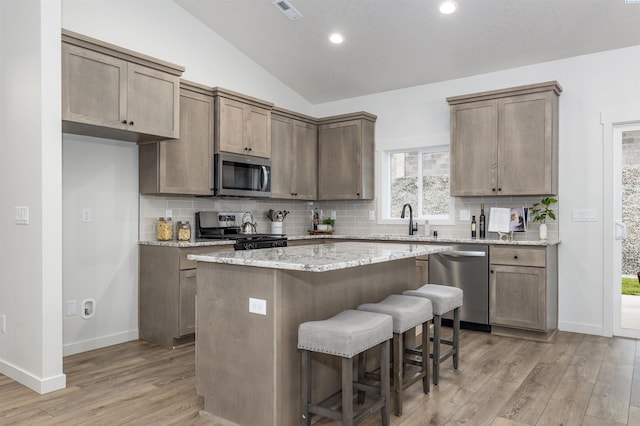 2408 Maggio Loop, Richland, WA 99352 - kitchen with a center island, tasteful backsplash, stainless steel appliances, and light wood finished floors